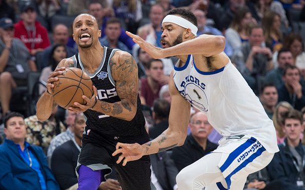 The Sacramento Kings' George Hill is fouled by the Golden State Warriors' JaVale McGee (1) in the f...