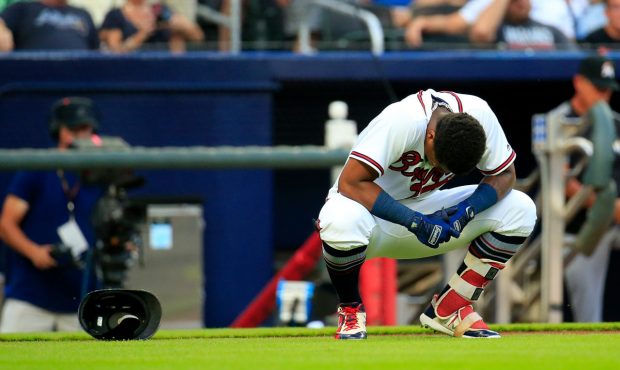ATLANTA, GA - AUGUST 15: Ronald Acuna Jr. #13 of the Atlanta Braves reacts to being hit by the firs...