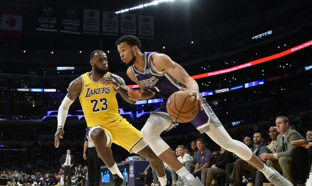 LeBron James #23 of the Los Angeles Lakers defends against Skal Labissiere #7 of the Sacramento Kin...