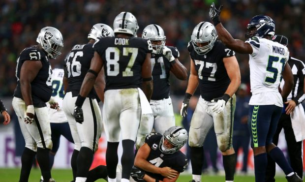 LONDON, ENGLAND - OCTOBER 14: Derek Carr #4 of the Oakland Raiders holds his arm as he lies injured...