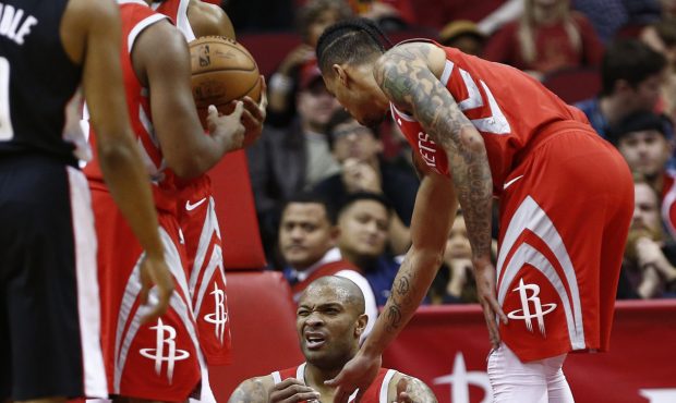 HOUSTON, TEXAS - DECEMBER 19: PJ Tucker #17 of the Houston Rockets is helped up by Gerald Green #14...