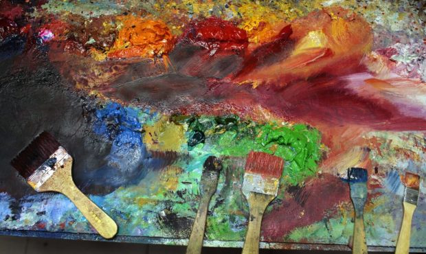SHENZHEN, CHINA - MAY 19: A rainbow of oil paint and brushes lie next to a painting as the artist t...