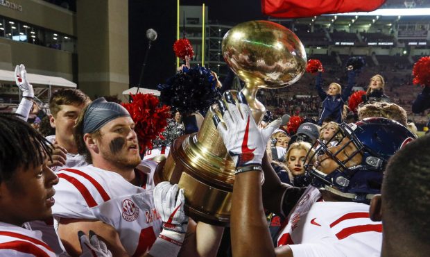 STARKVILLE, MS - NOVEMBER 23: Mississippi Rebels players celebrate by hoisting the Egg Bowl trophy ...
