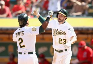 OAKLAND, CA - MARCH 29: Khris Davis #2 of the Oakland Athletics is congratulated by Matt Joyce #23 after he hit a three-run home run against the Los Angeles Angels in the fifth inning at Oakland Alameda Coliseum on March 29, 2018 in Oakland, California. (Photo by Ezra Shaw/Getty Images)