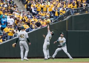 SEATTLE, WA - APRIL 15: Marcus Semien #10 of the Oakland Athletics, center, grabs the pop fly by Nelson Cruz #23 of the Seattle Mariners in the fourth inning, supported by Matt Chapman #26, left and Matt Joyce #23, right, at Safeco Field on April 15, 2018 in Seattle, Washington. All players are wearing #42 in honor of Jackie Robinson Day. (Photo by Lindsey Wasson/Getty Images)