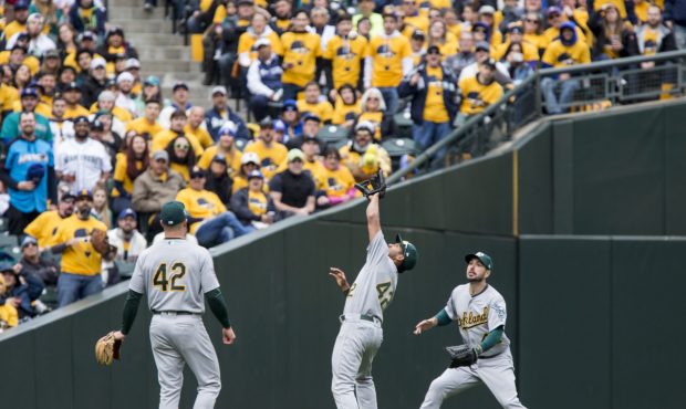 SEATTLE, WA - APRIL 15: Marcus Semien #10 of the Oakland Athletics, center, grabs the pop fly by Ne...