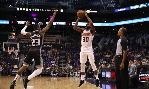 PHOENIX, ARIZONA - DECEMBER 04: Troy Daniels #30 of the Phoenix Suns attempts a three-point shot ag...