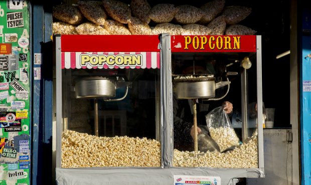 A man scoops fresh popcorn from a brightly coloured popcorn dispenser on the 25th February 2019 in ...