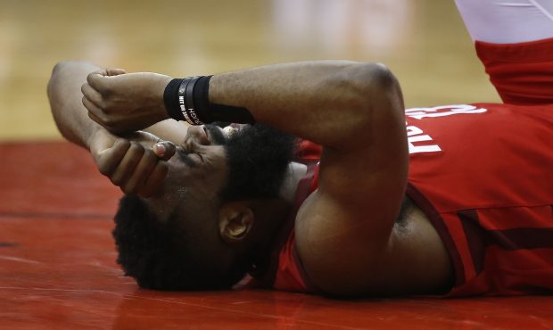 HOUSTON, TEXAS - APRIL 14: James Harden #13 of the Houston Rockets lays on the court after taking a...