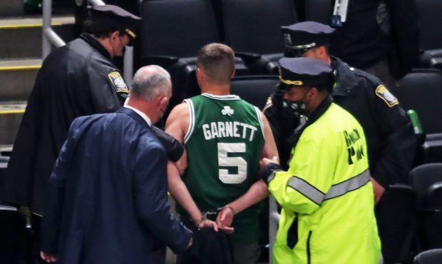 Boston - May 30: A man who was believed to throw a water bottle towards Kyrie Irving is escorted ou...