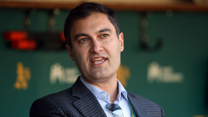 Oakland Athletics president Dave Kaval, left, talks with Reggie