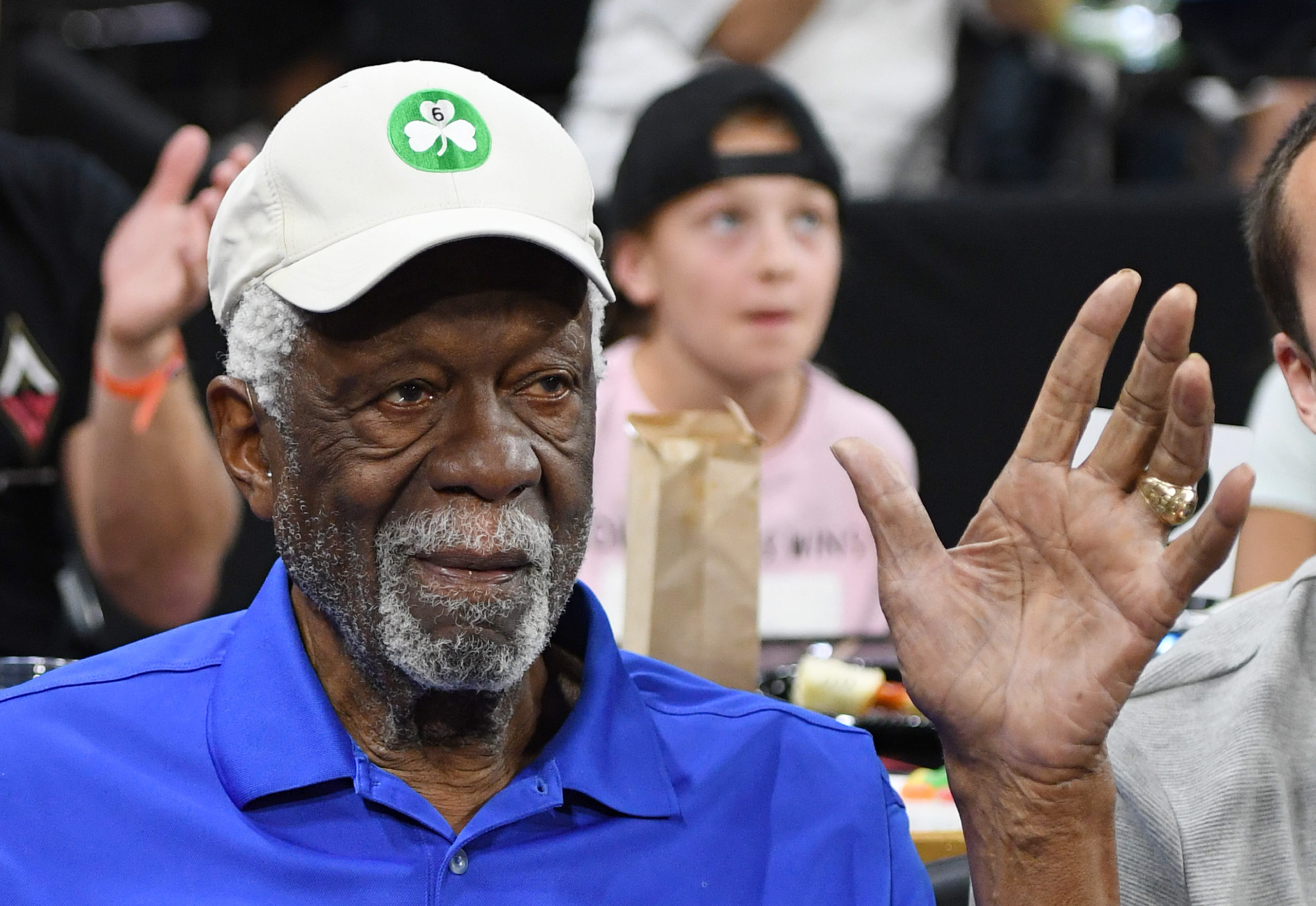 Bill Russell waves to fans at an NBA game....
