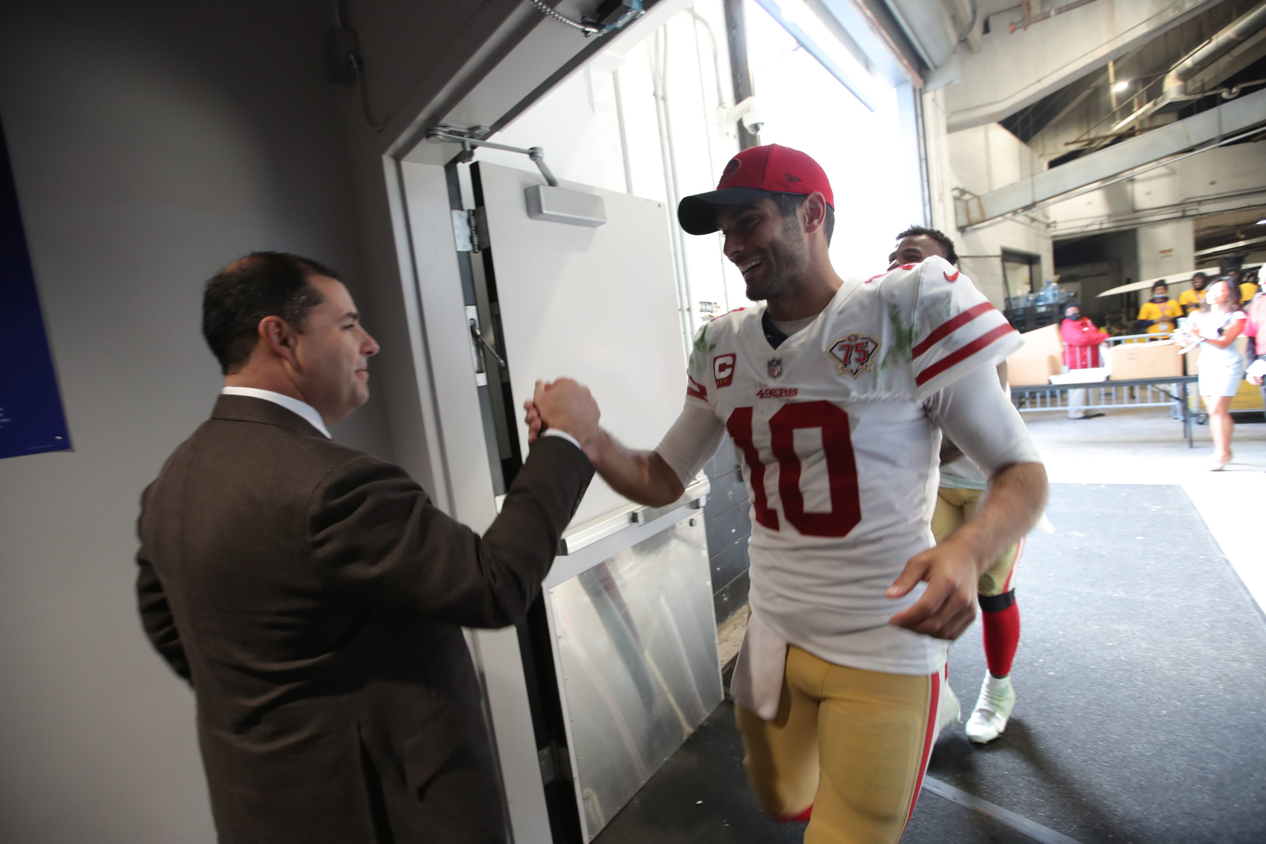 CEO Jed York of the San Francisco 49ers congratulates Jimmy Garoppolo #10 in the locker room after ...