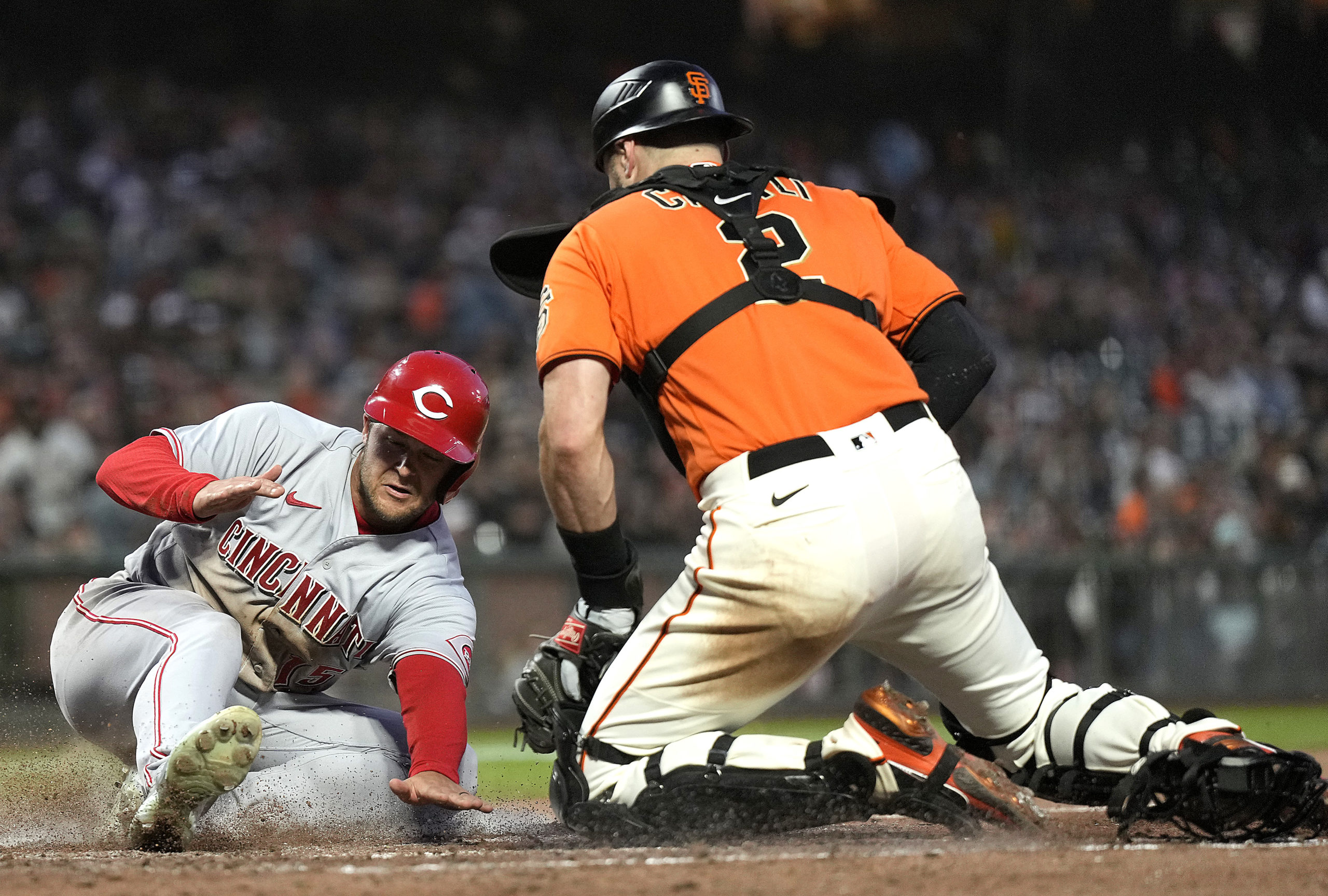 Nick Senzel of the Cincinnati Reds scores as Curt Casali of the San Francisco Giants can't handle t...