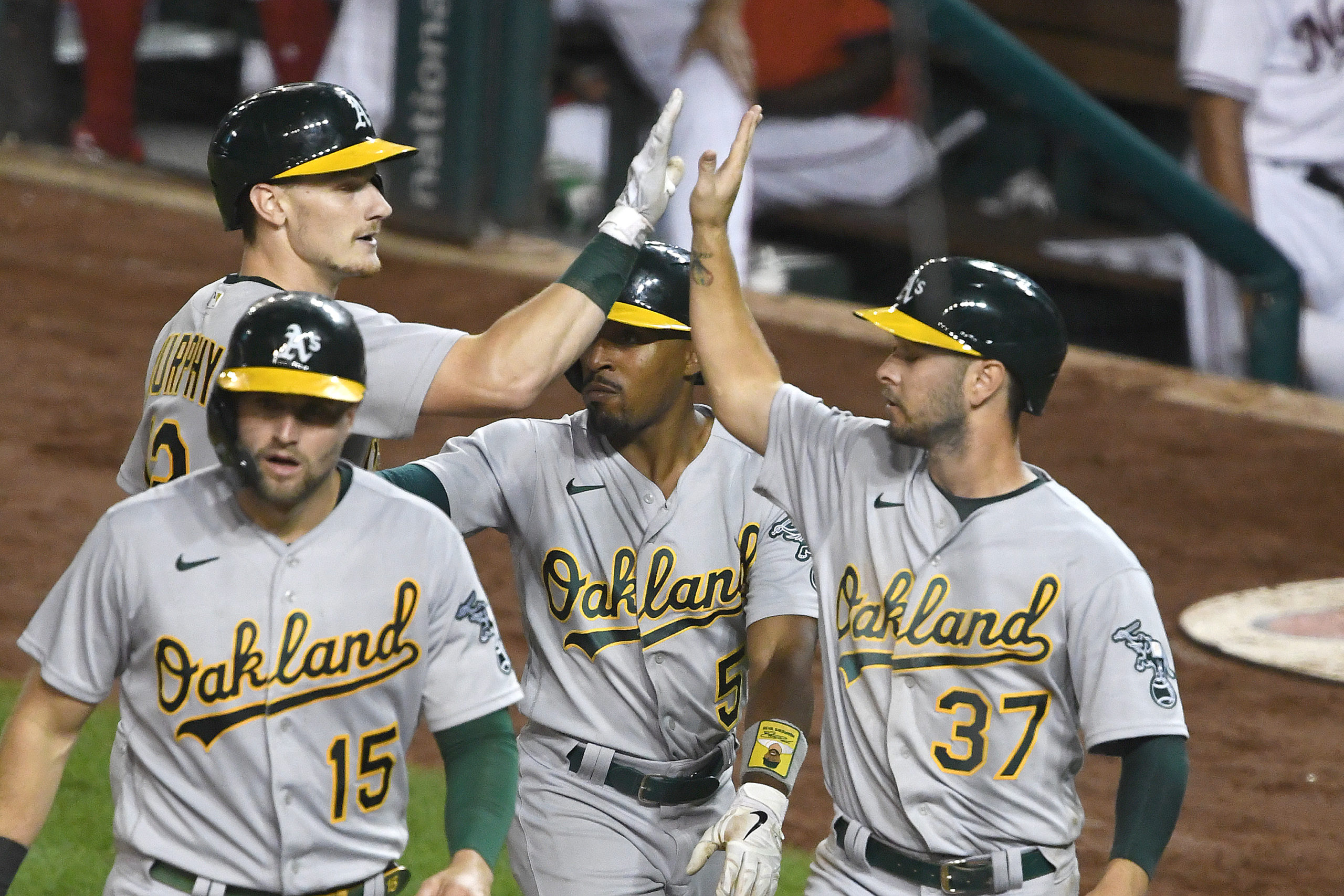 Sean Murphy #12 of the Oakland A's celebrates a grand slam in the fifth inning with Seth Brown #15,...