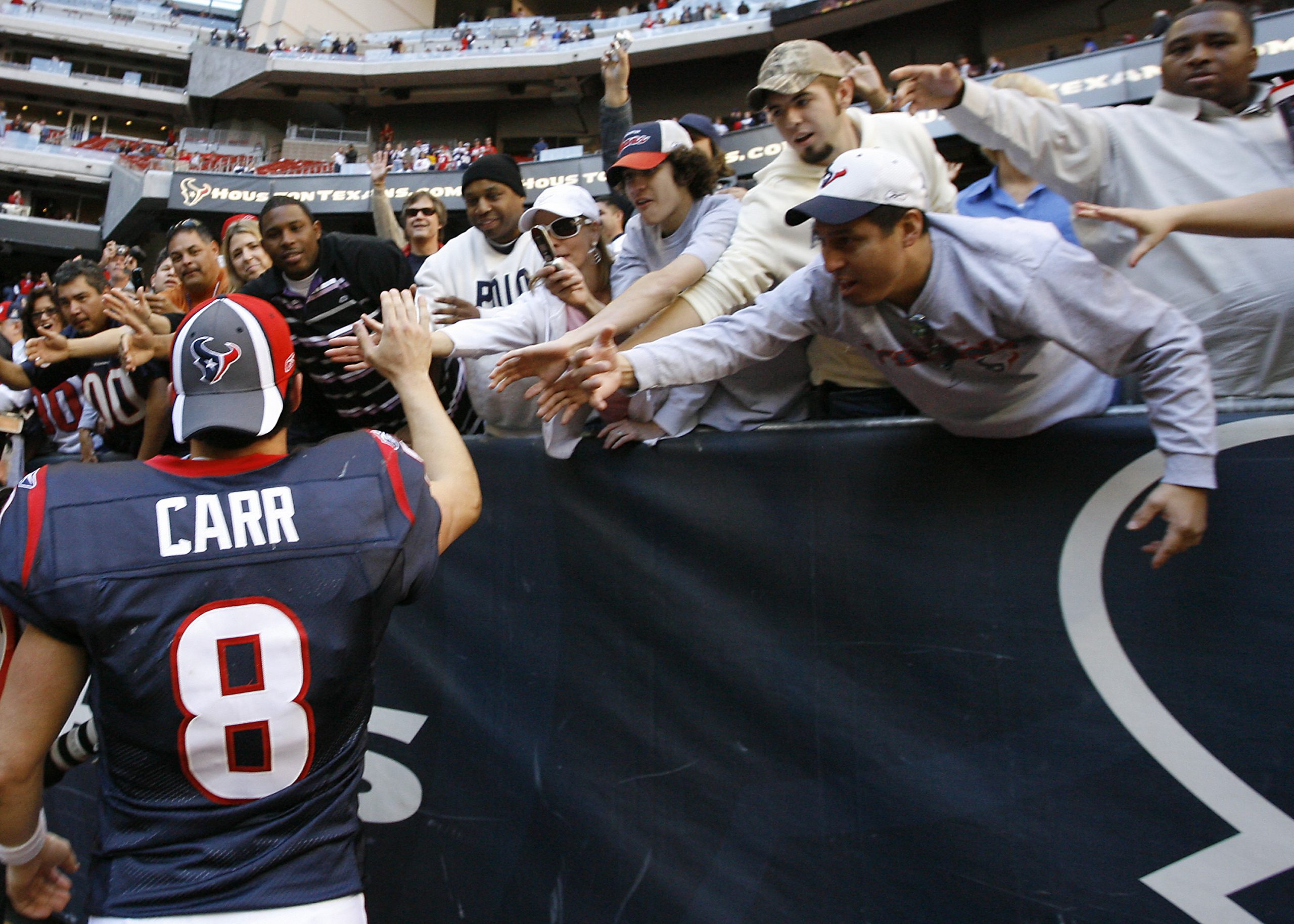 Houston Texans quarterback David Carr (8) high fives some fans as he leaves the field .The Houston ...
