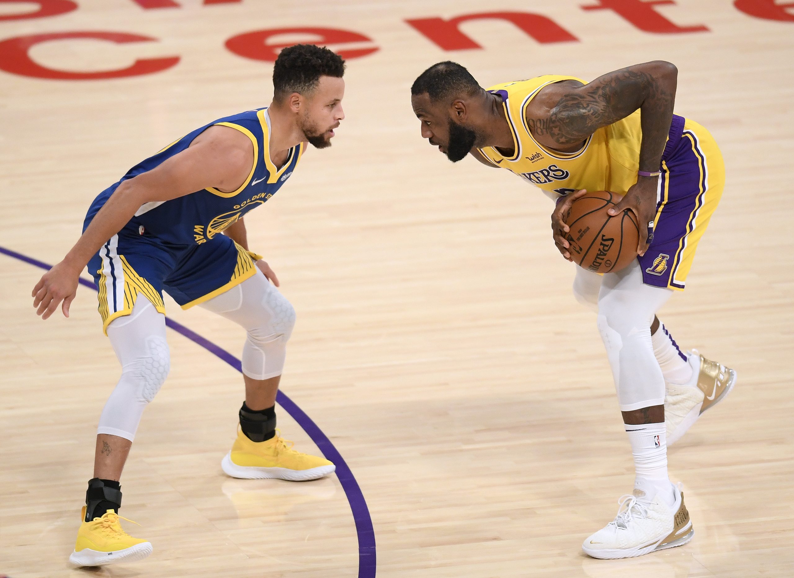 NBA stars LeBron James #23 of the Los Angeles Lakers is guarded by Stephen Curry #30 of the Golden ...