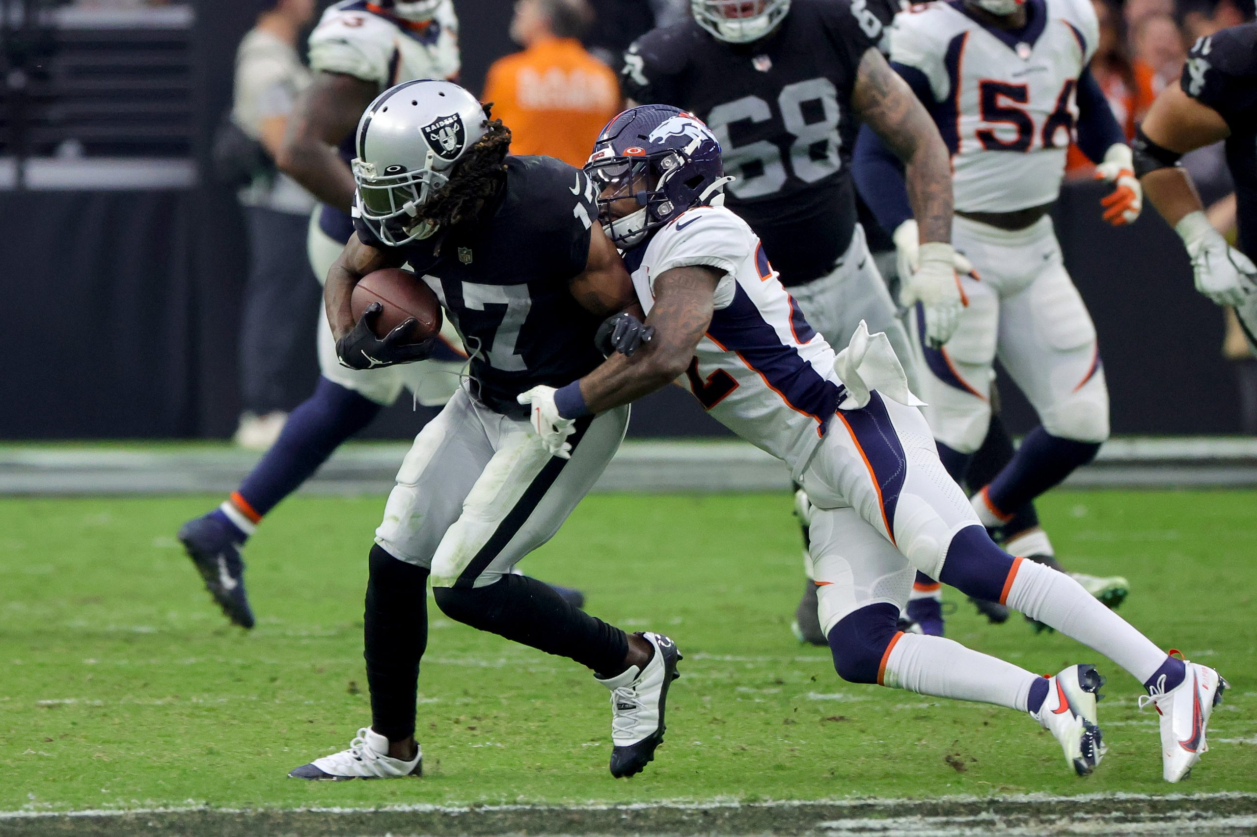 Davante Adams #17 of the Las Vegas Raiders runs with the ball while being tackled by Kareem Jackson...