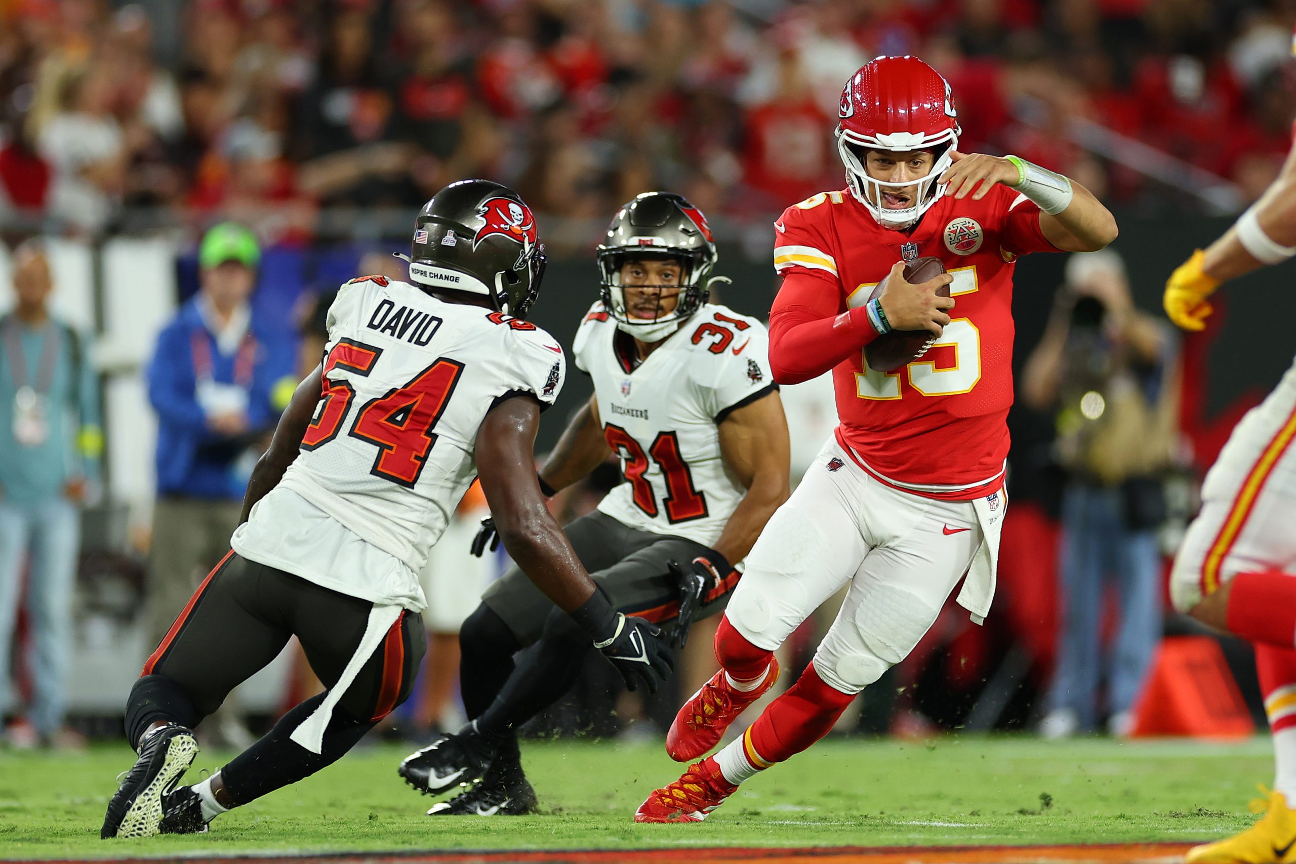 Patrick Mahomes #15 of the Kansas City Chiefs runs with the ball against Lavonte David #54 of the T...