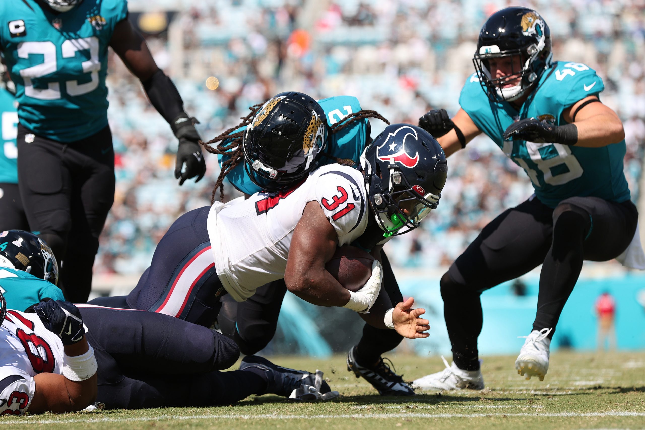 Dameon Pierce #31 of the Houston Texans is tackled by Rayshawn Jenkins #2 of the Jacksonville Jagua...