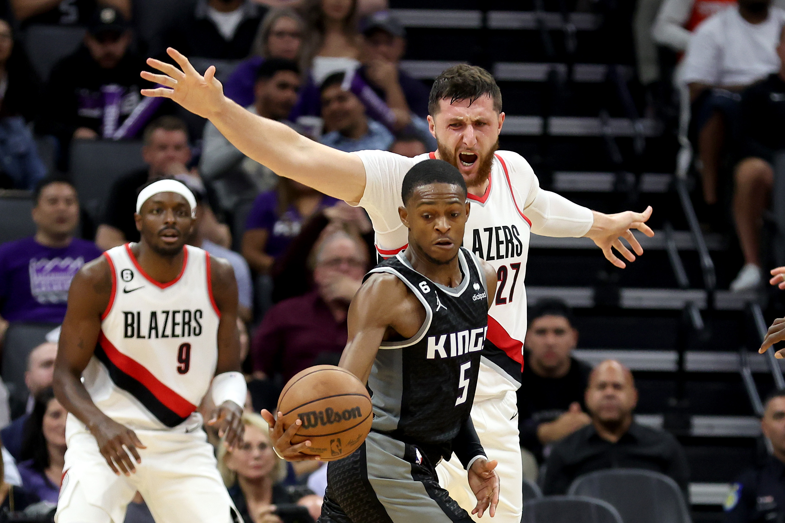De'Aaron Fox #5 of the Sacramento Kings is guarded by Jusuf Nurkic #27 of the Portland Trail Blazer...