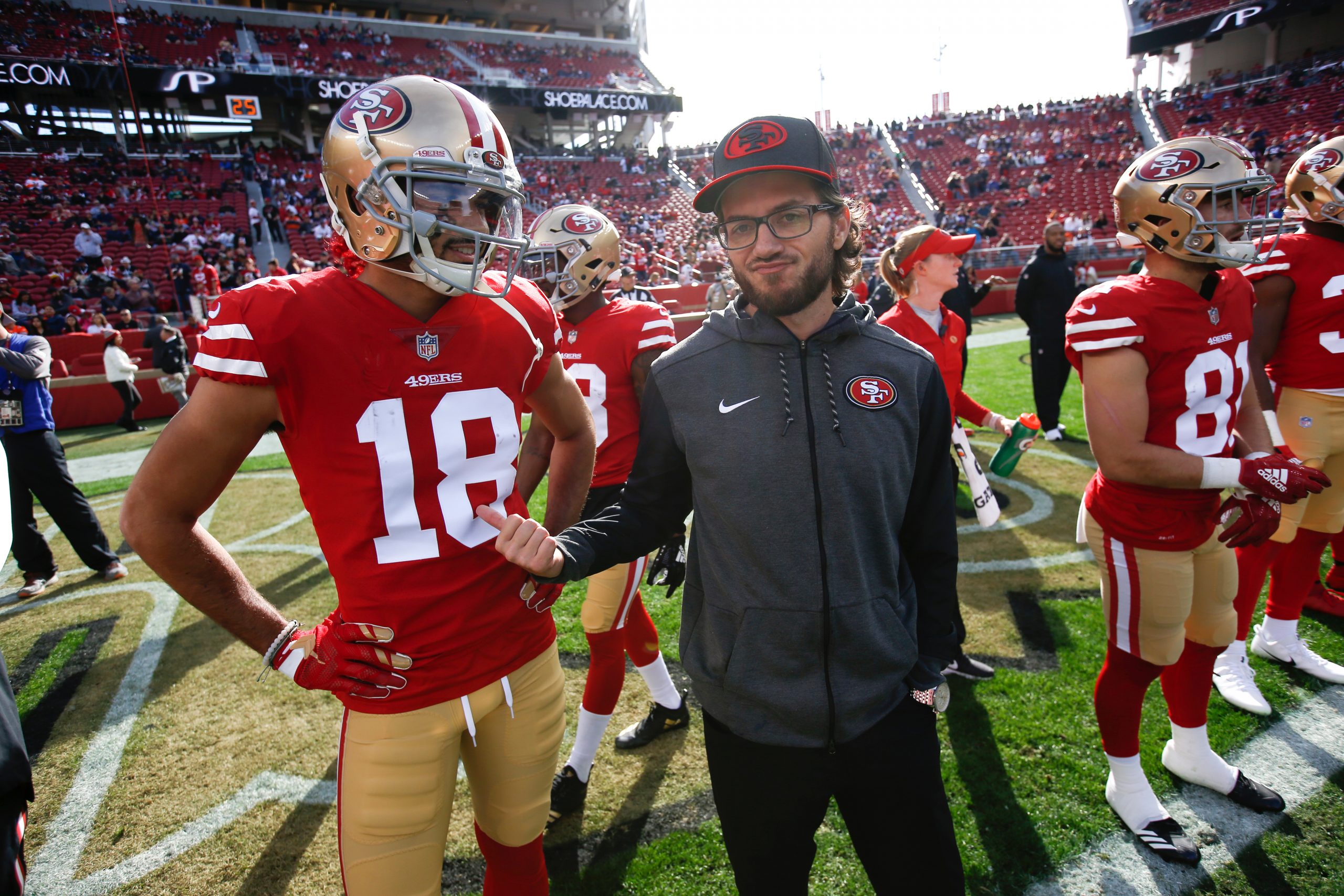 Dante Pettis #18 and Run Game Coordinator Mike McDaniel of the San Francisco 49ers talk on the fiel...