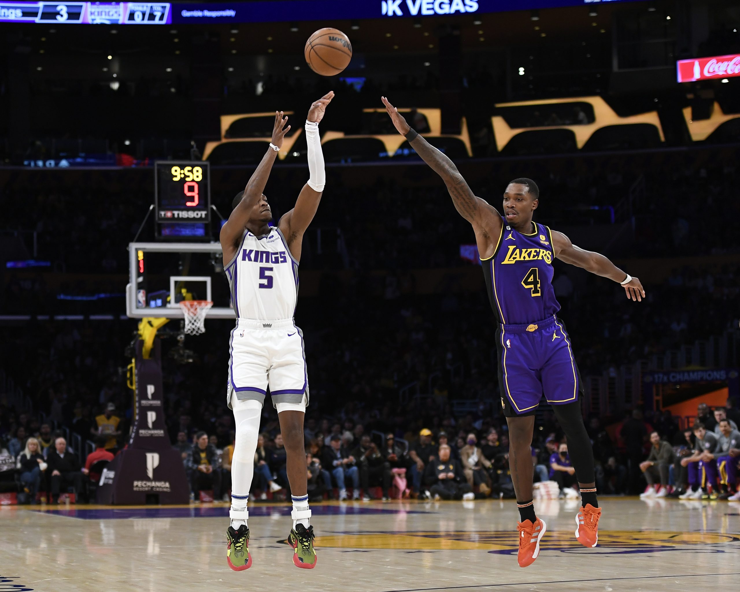 Sacramento Kings guard De'Aaron Fox shoots a three-point basket against Lonnie Walker IV #4 of the ...