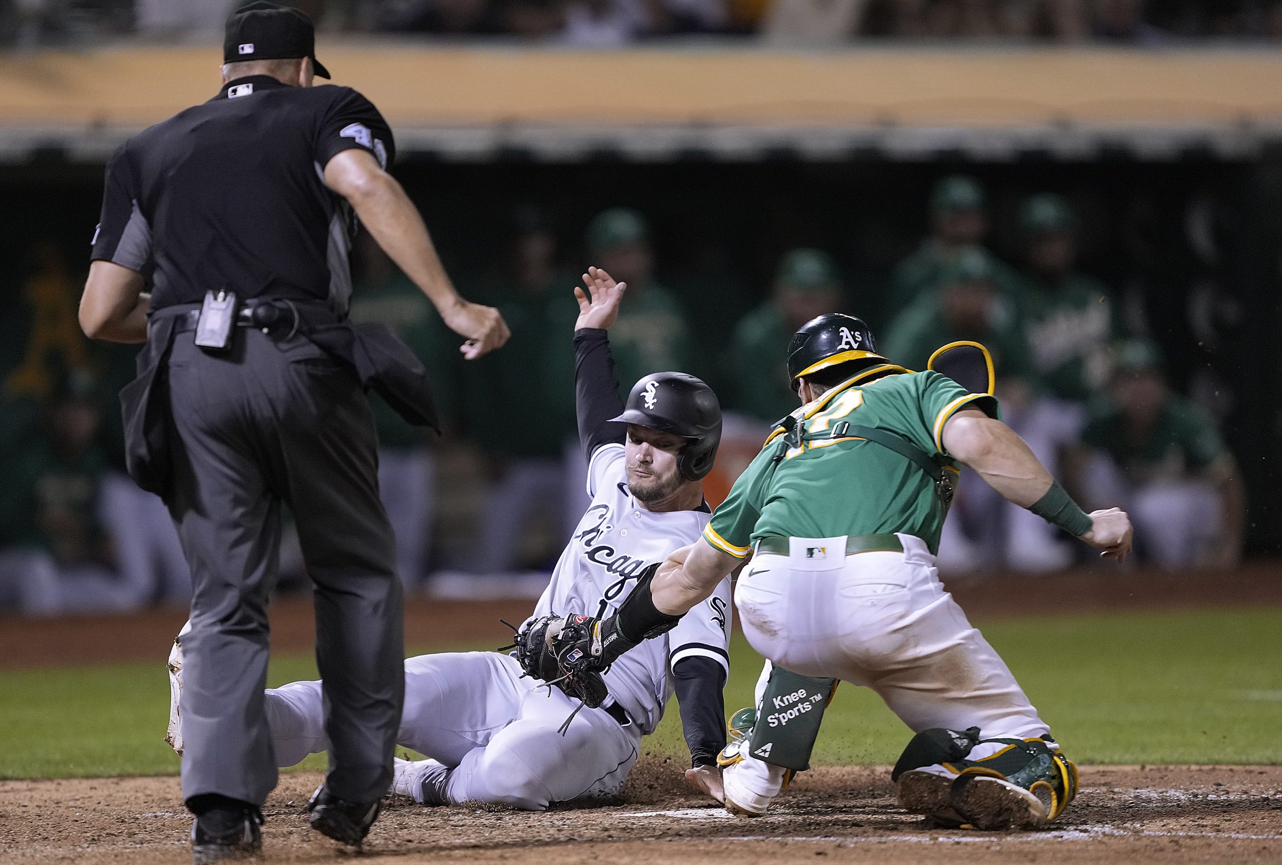 Adam Engel #15 of the Chicago White Sox scores ahead of the tag from Sean Murphy #12 of the Oakland...