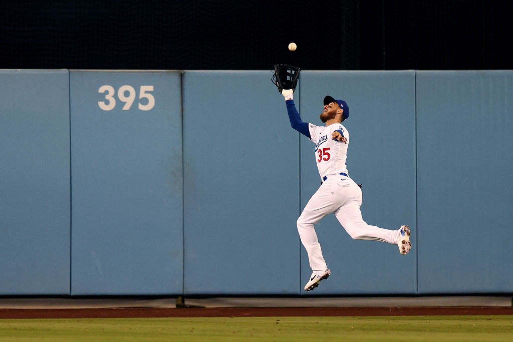 Cody Bellinger #35 of the Los Angeles Dodgers makes a running catch on a hit by Austin Nola #26 of ...