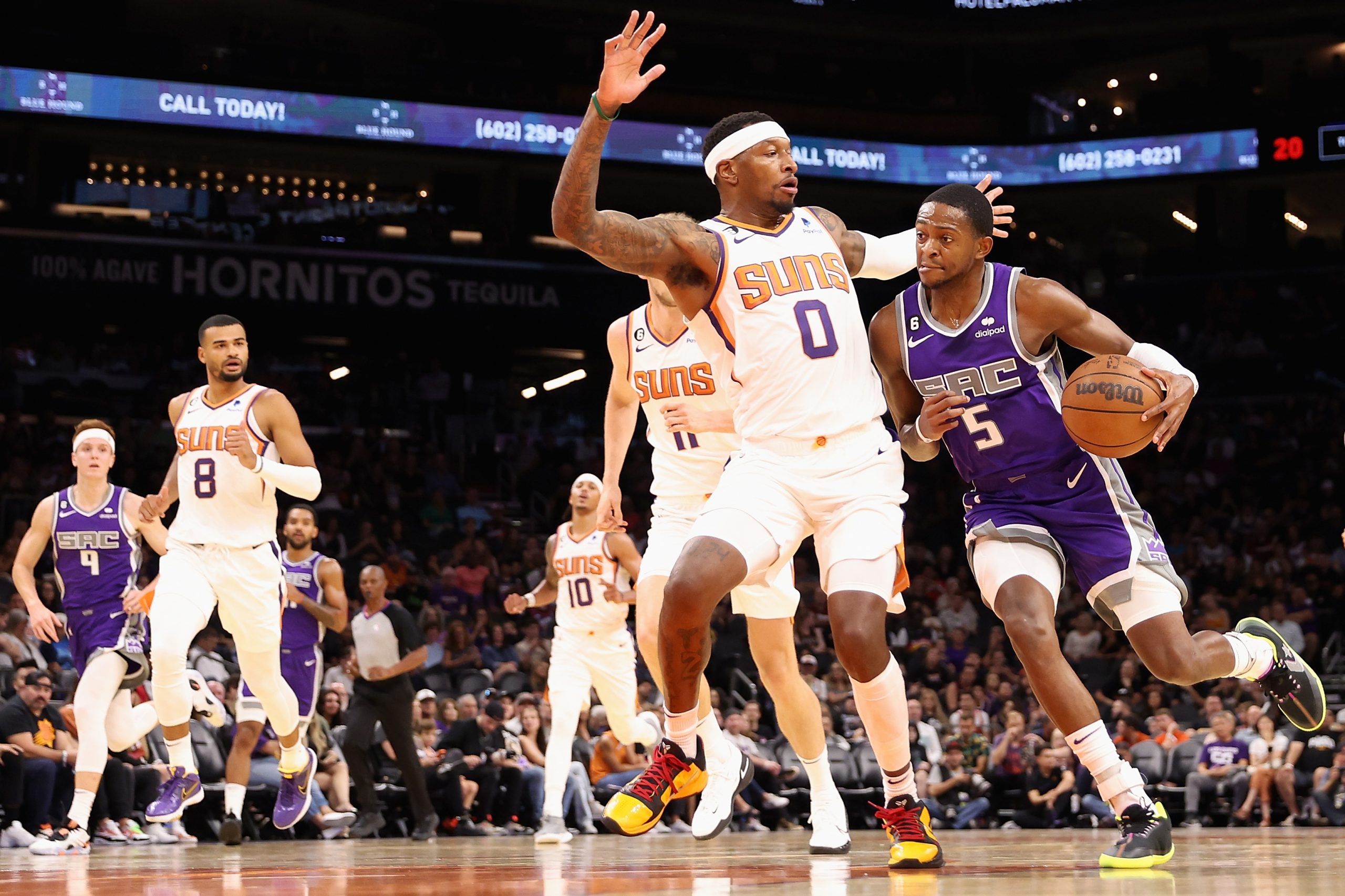 Sacramento Kings guard De'Aaron Fox drives the ball against Torrey Craig #0 of the Phoenix Suns dur...