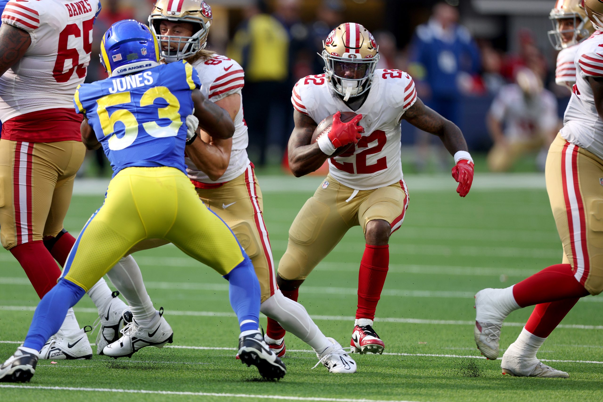 Jeff Wilson Jr. #22 of the San Francisco 49ers runs behind a block from George Kittle #85 on Ernest...