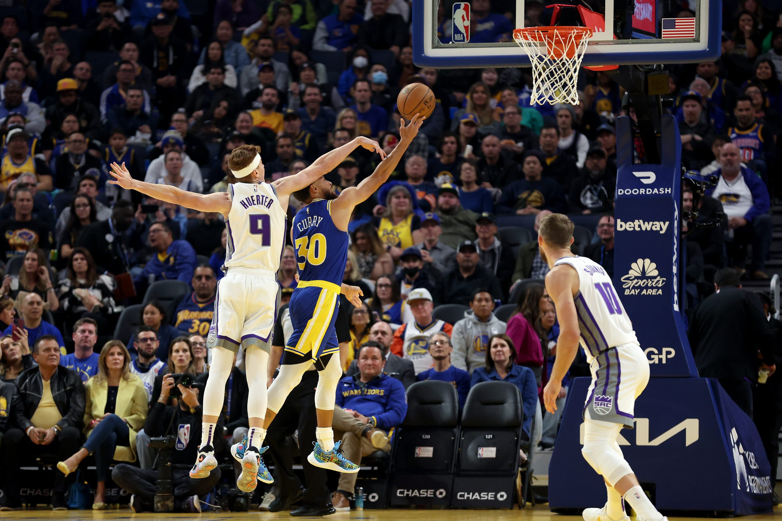 Stephen Curry #30 of the Golden State Warriors goes up for a shot on Kevin Huerter #9 of the Sacram...