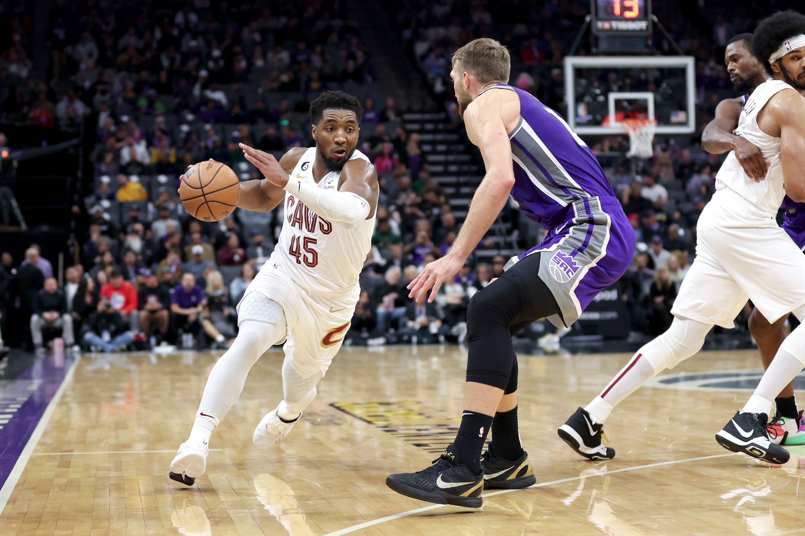 Donovan Mitchell #45 of the Cleveland Cavaliers is guarded by omantas Sabonis #10 of the Sacramento...