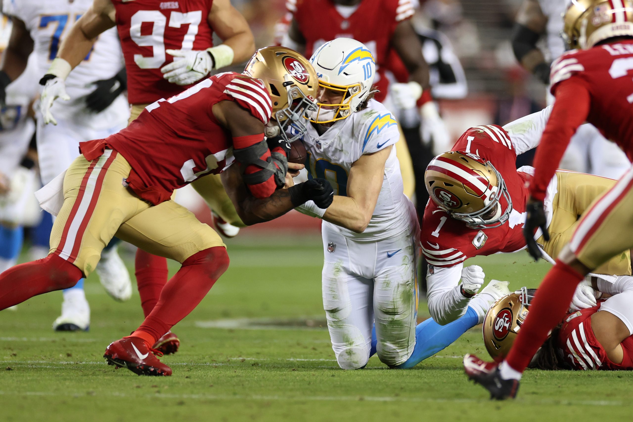 Dre Greenlaw #57 of the San Francisco 49ers hits Justin Herbert #10 of the Los Angeles Chargers dur...