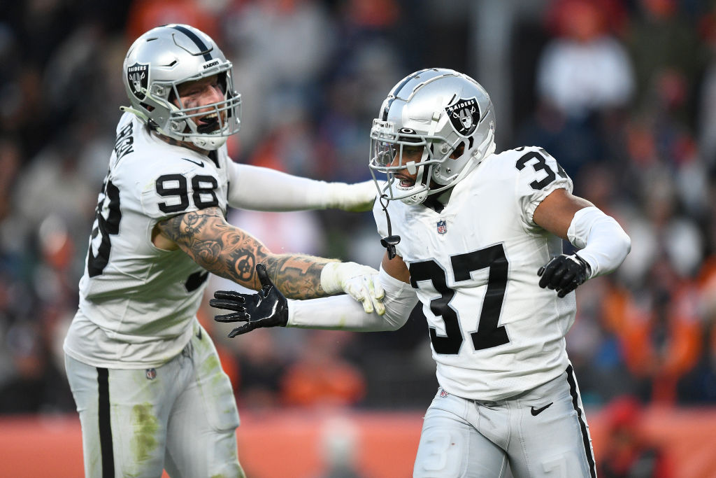 Tyler Hall #37 celebrates with Maxx Crosby #98 of the Las Vegas Raiders after Hall recorded a sack ...