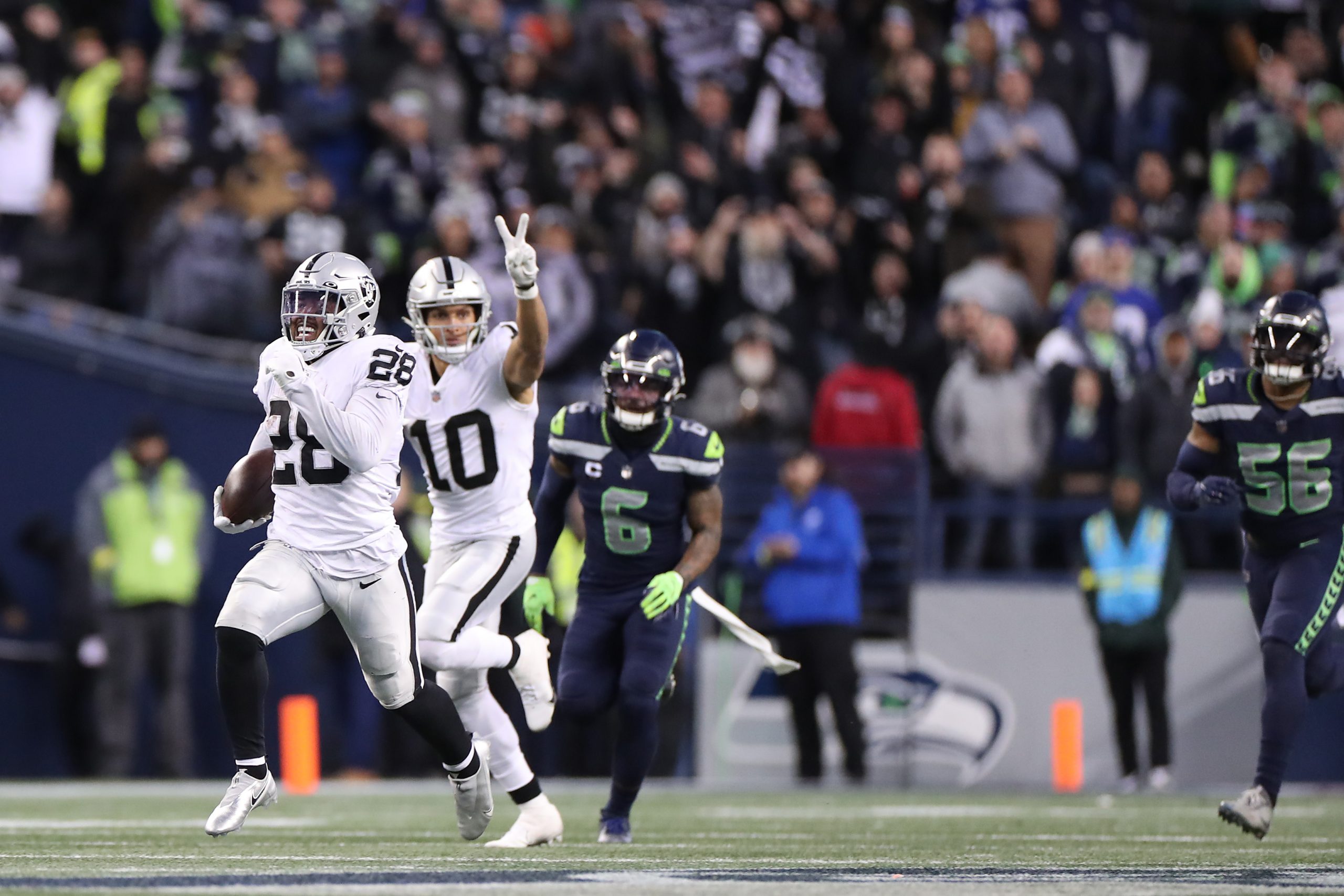 Josh Jacobs #28 of the Las Vegas Raiders runs with the ball in overtime against the Seattle Seahawk...