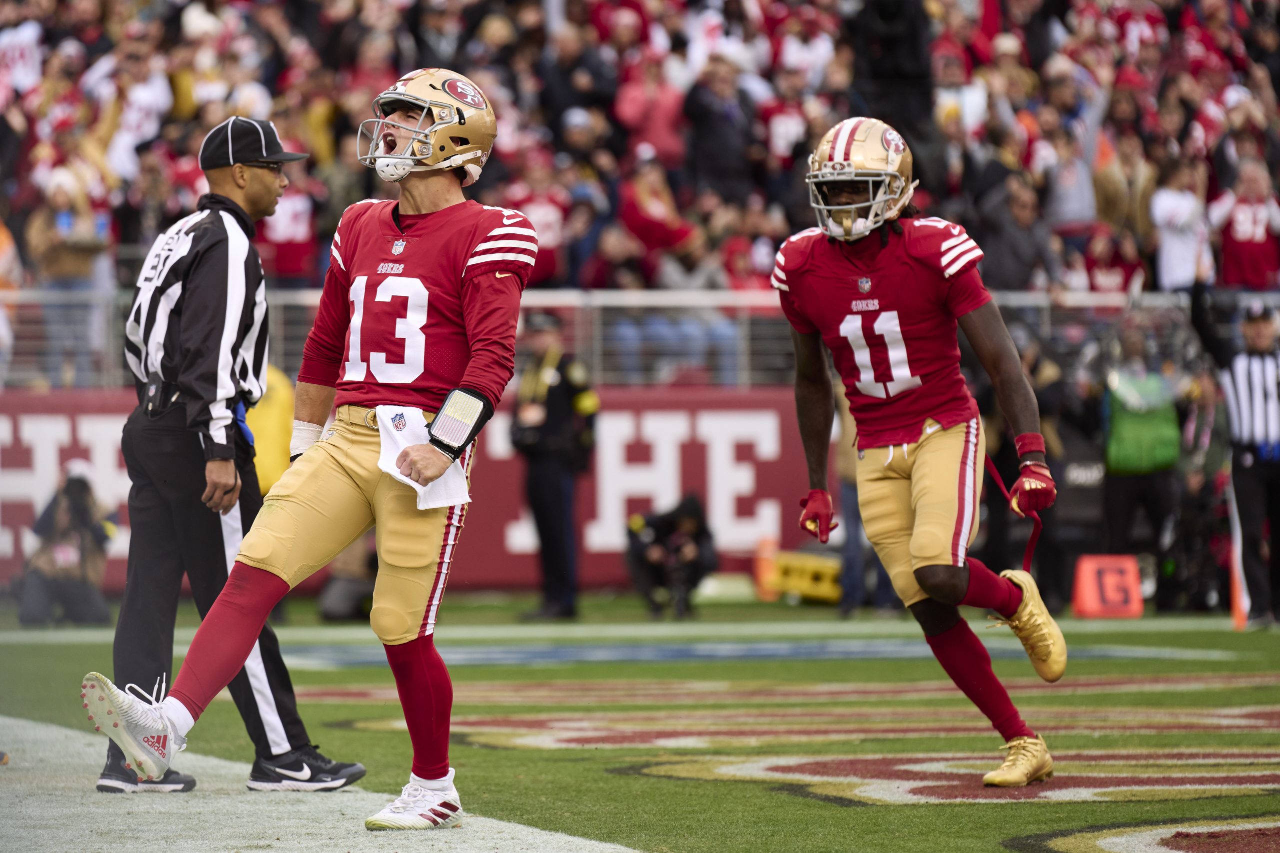 Brock Purdy #13 of the San Francisco 49ers celebrates after rushing for a touchdown against the Tam...