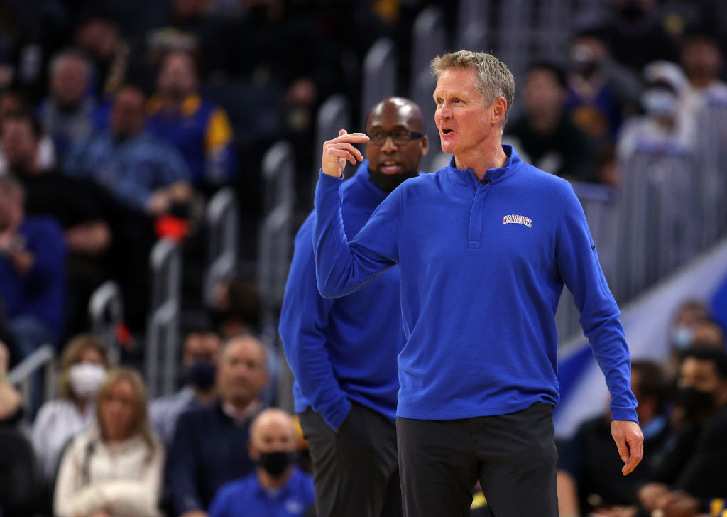 Golden State Warriors head coach Steve Kerr, with assistant coach Mike Brown behind him, gestures t...