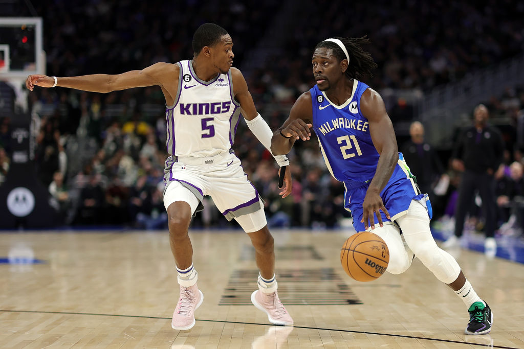 Jrue Holiday #21 of the Milwaukee Bucks is defended by De'Aaron Fox #5 of the Sacramento Kings duri...