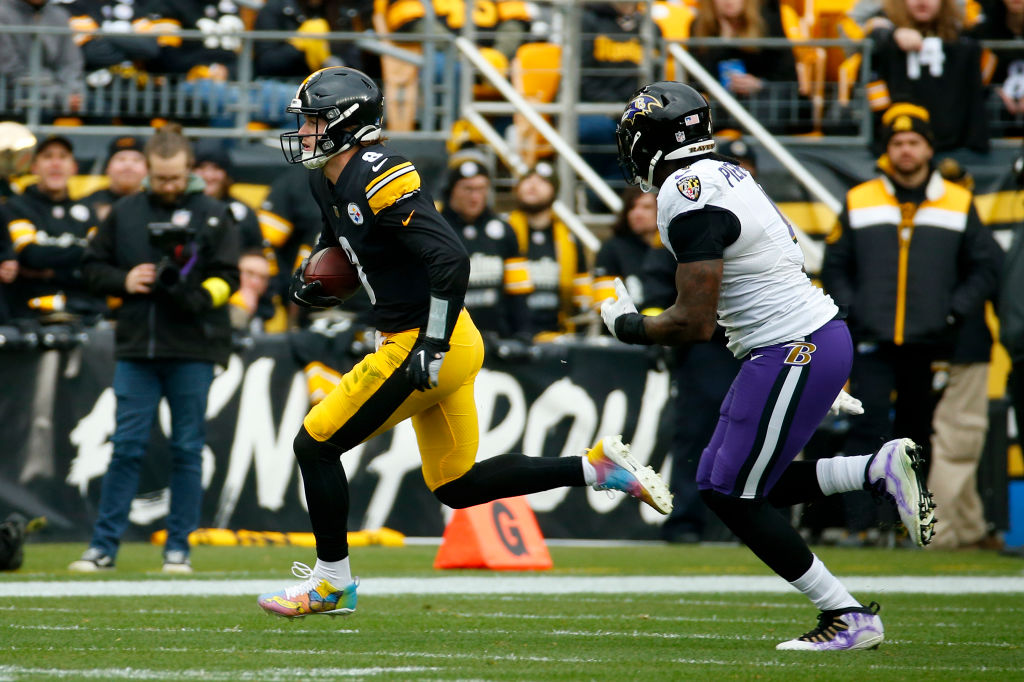 Kenny Pickett #8 of the Pittsburgh Steelers runs with the ball as Jason Pierre-Paul #4 of the Balti...
