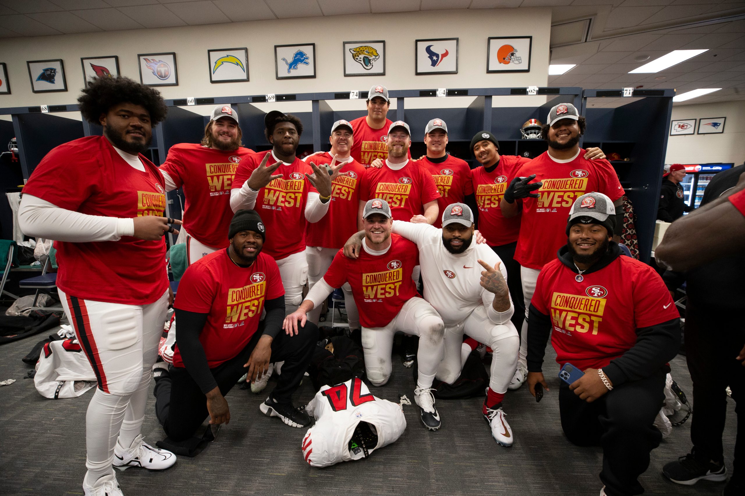 The San Francisco 49ers offensive line celebrates in the locker room after clinching the NFC West a...