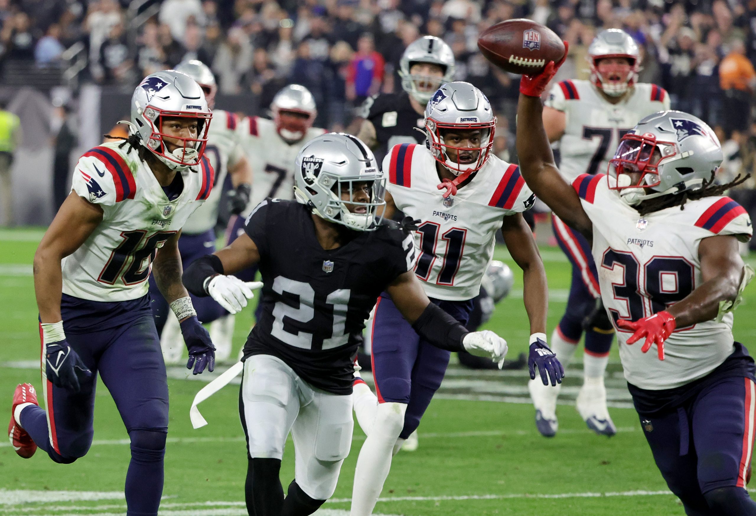 Running back Rhamondre Stevenson #38 of the New England Patriots pitches the ball back to wide rece...