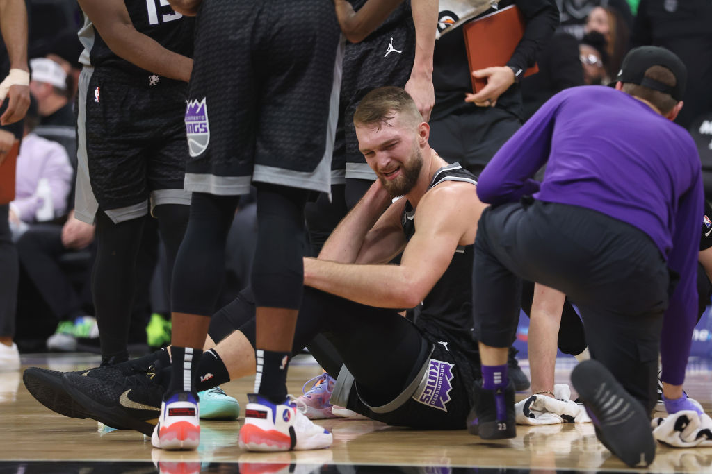 Domantas Sabonis #10 of the Sacramento Kings sits on the floor after being fouled in the fourth qua...