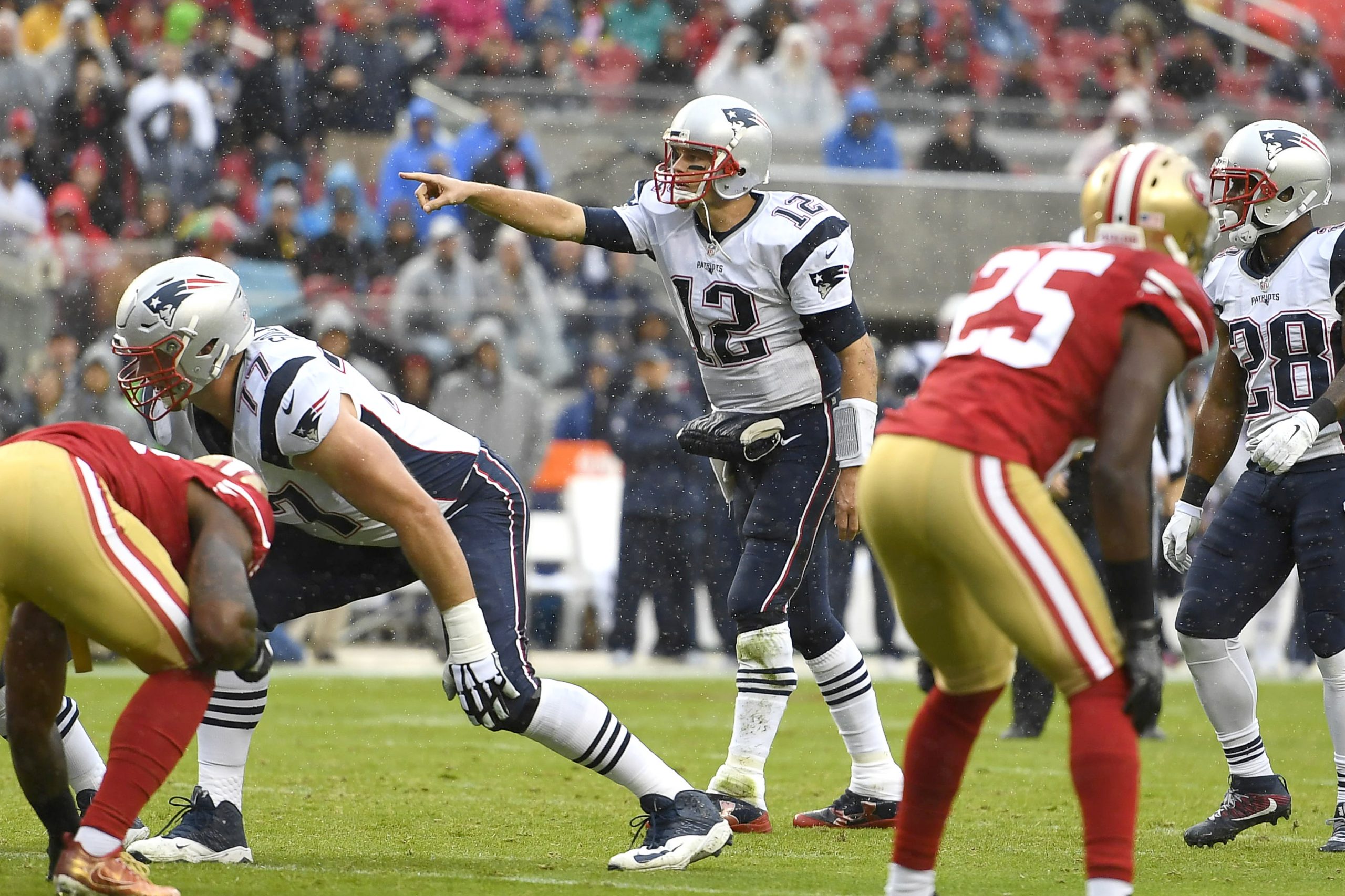 New England Patriots quarterback Tom Brady (12) points to a teammate before a snap in the second qu...