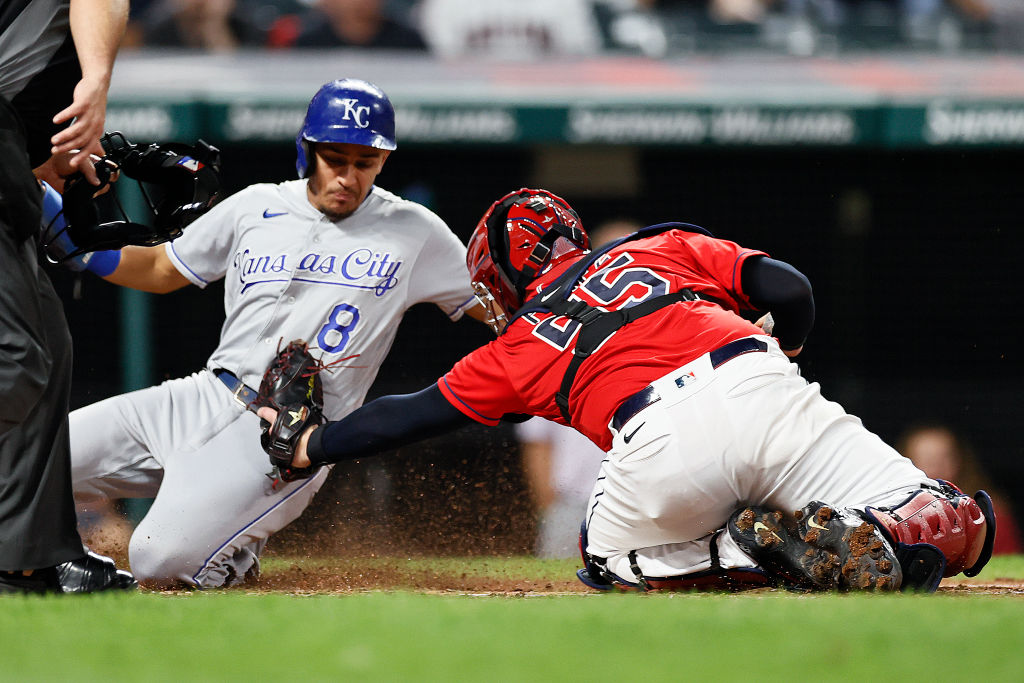 Nicky Lopez #8 of the Kansas City Royals is tagged out at home plate by Roberto Perez #55 of the Cl...