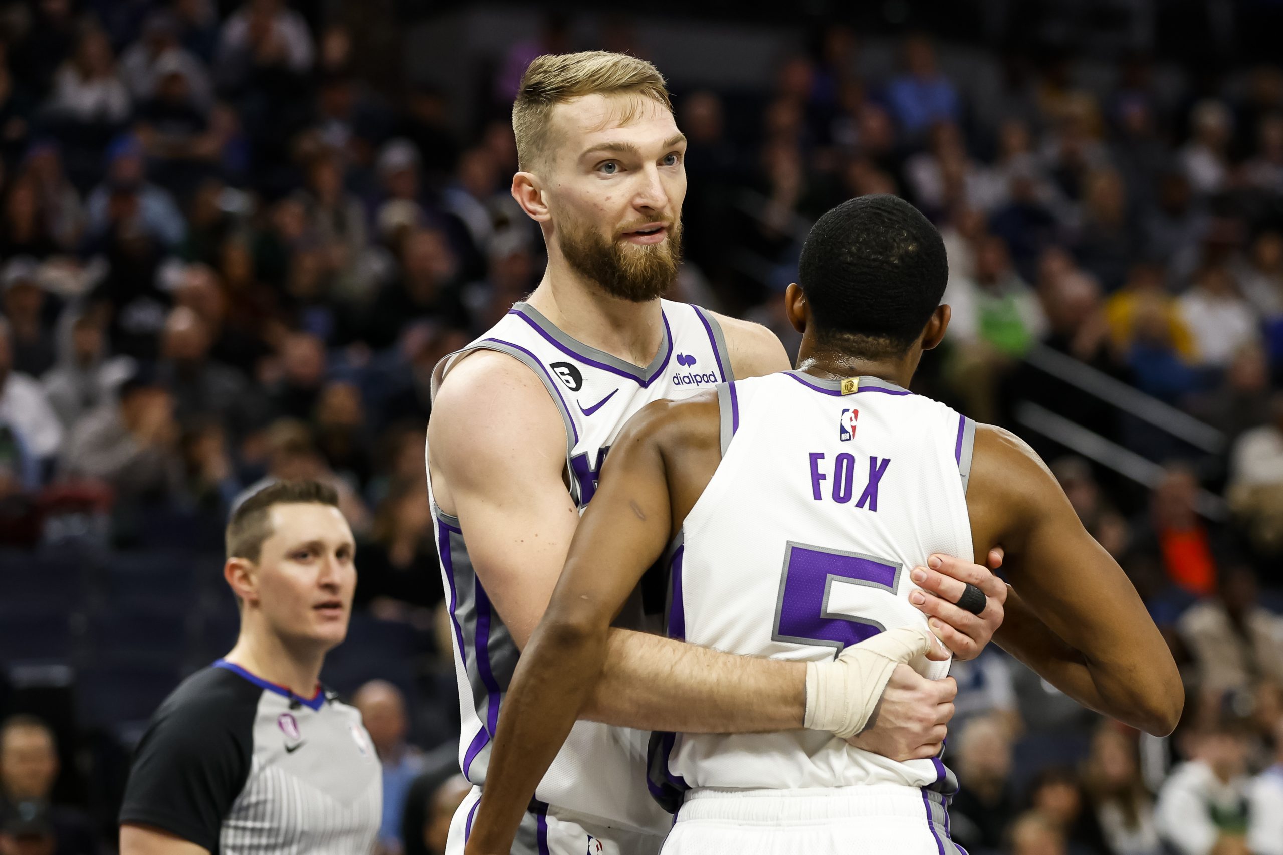 The Sacramento Kings Domantas Sabonis holds back De'Aaron Fox as he reacts to a foul call in the fo...