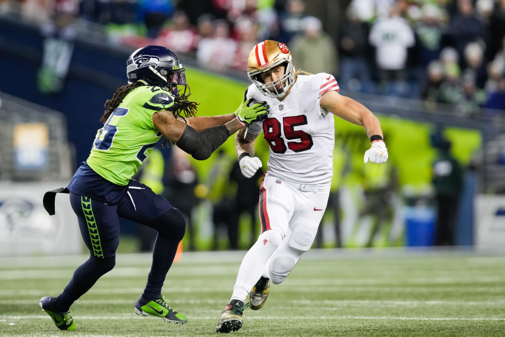 George Kittle #85 of the San Francisco 49ers runs a route against Ryan Neal #26 of the Seattle Seah...
