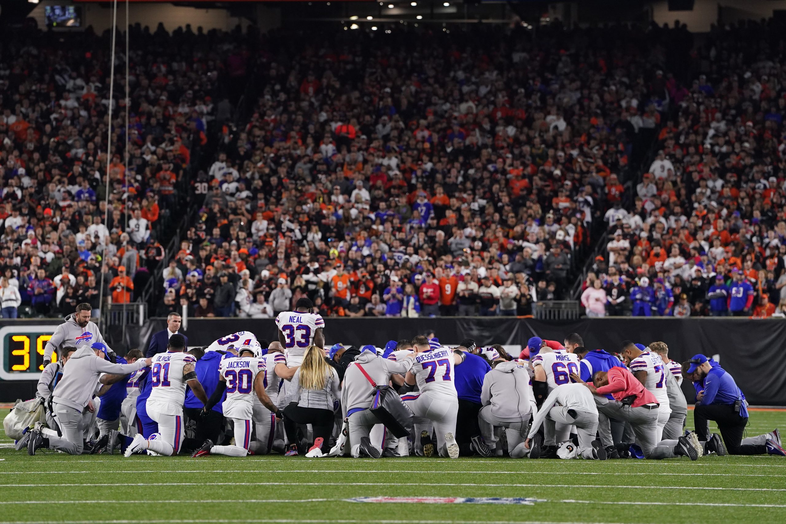 NFL Buffalo Bills players huddle and pray after teammate Damar Hamlin #3 collapsed on the field aft...