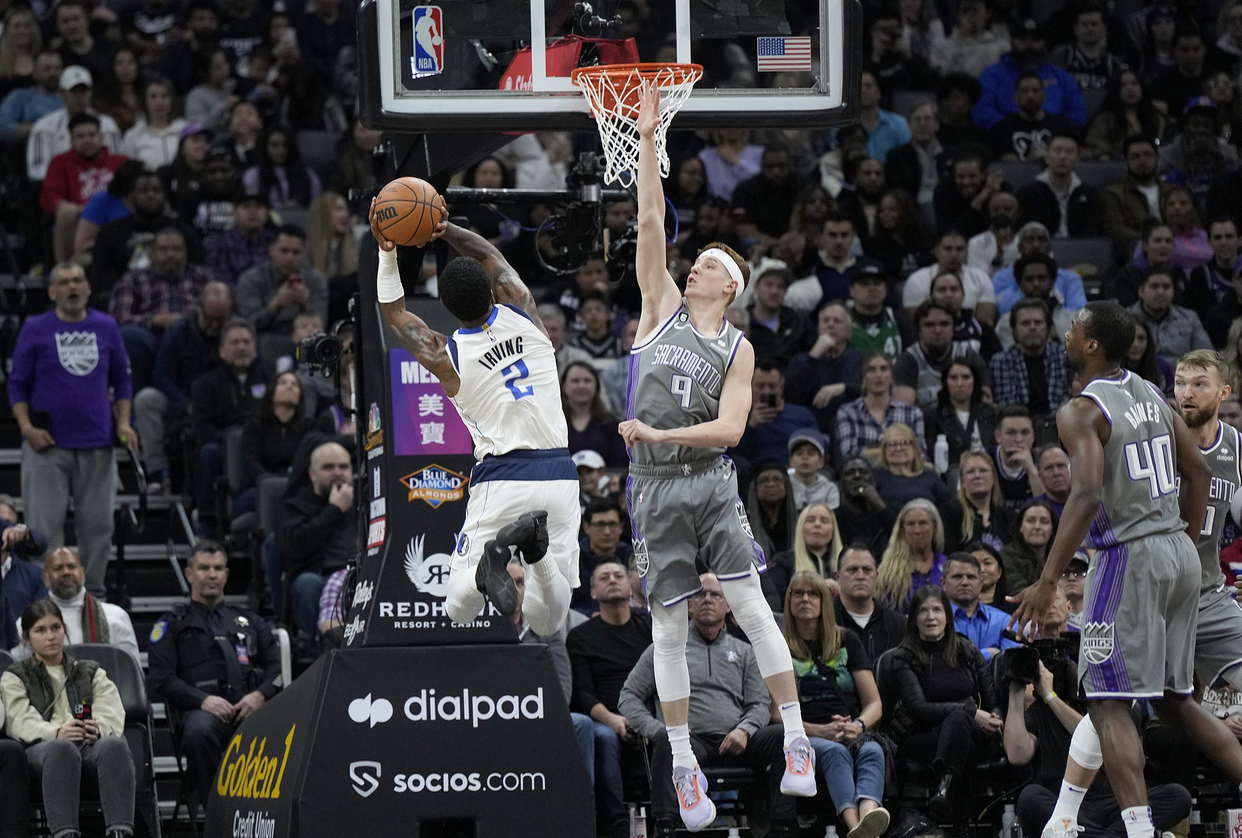 Kyrie Irving #2 of the Dallas Mavericks shoots over Kevin Huerter #9 of the Sacramento Kings and ge...