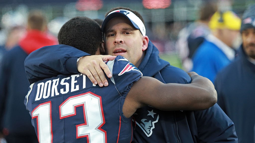 New England Patriots offensive coordinator Josh McDaniels hugs Phillip Dorsett #13 after their 38-3...